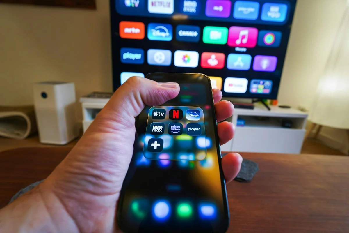 Smartphone streaming app interface displayed in front of a large smart TV in a modern living room